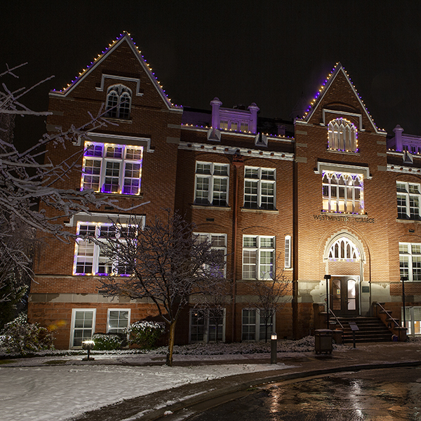 Westminster College's Converse building lit with purple lights in celebration of the holiday season.