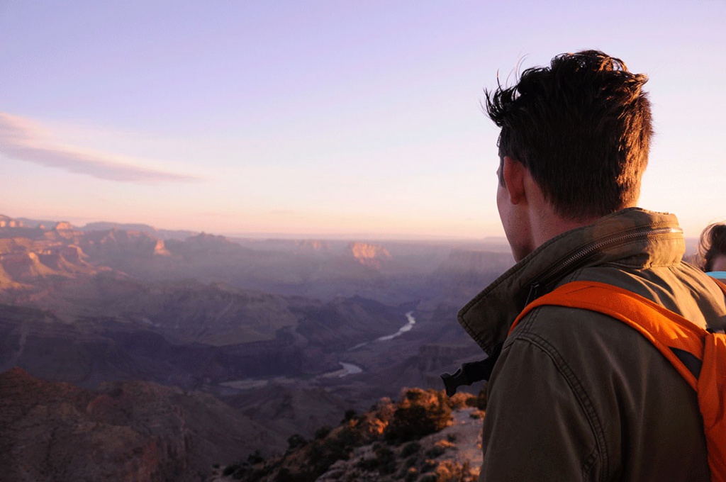 Man looks over mountains at sunset