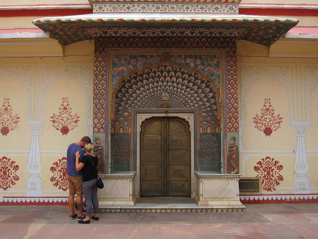couple in front of decorative wall
