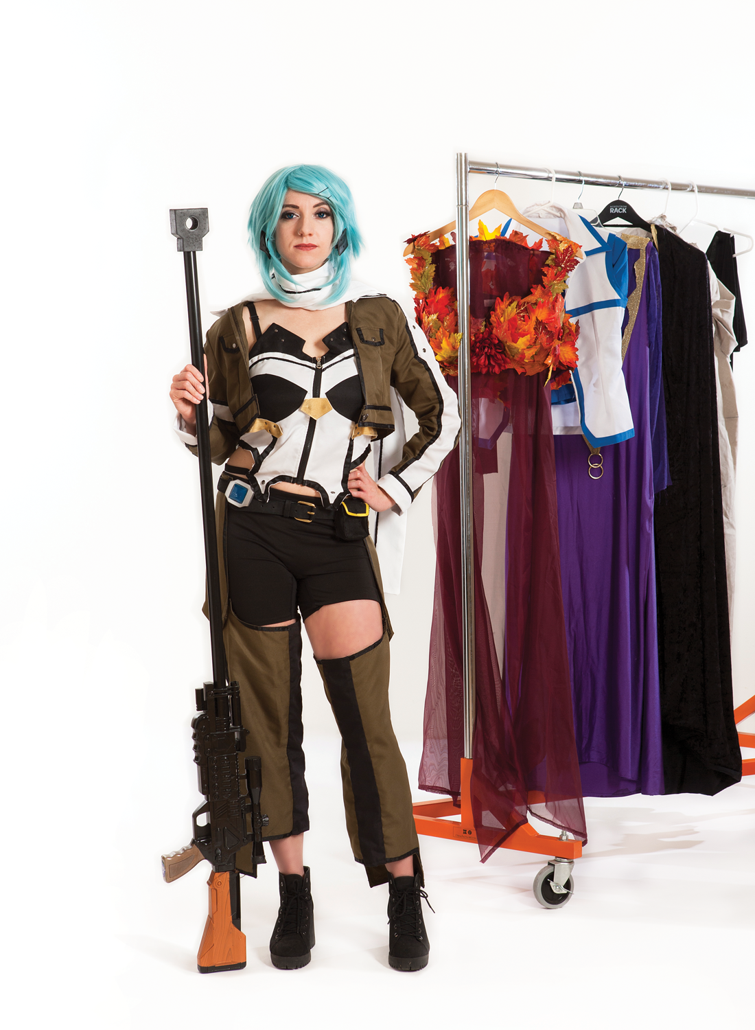 Alysa Fratto poses in cosplay, and on the background there is a clothing rack showcasing other cosplays she created. 