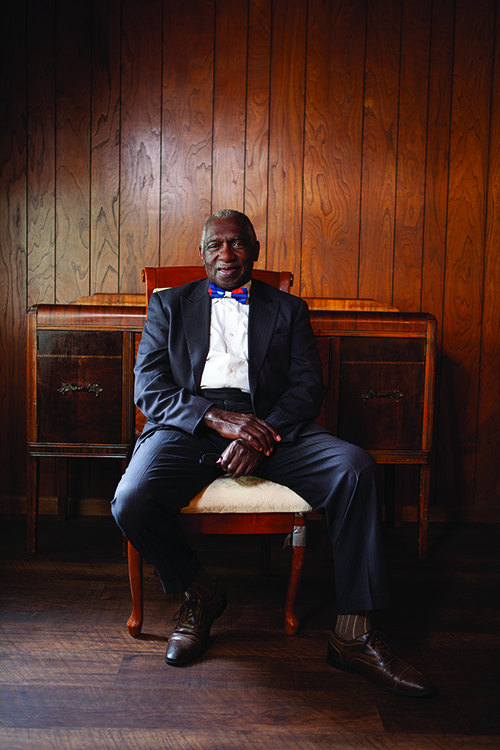 Reverend Frances Davis sitting on chair in suit 