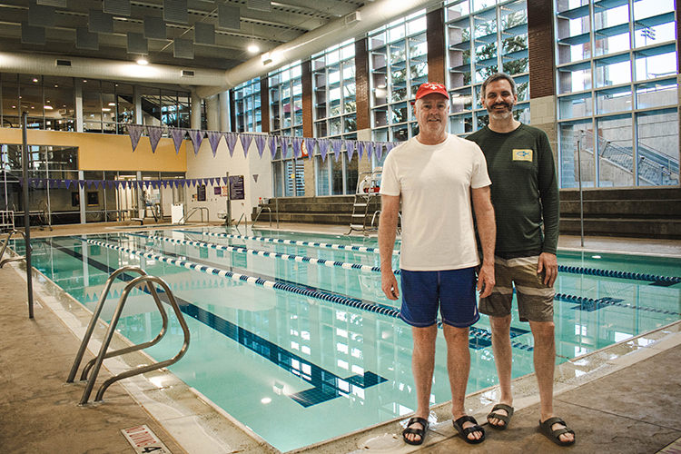 Patrick and Aaron stand in front of the pool at Westminster's aquatic center